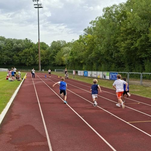 Kinder, die auf der Tartanbahn sprinten